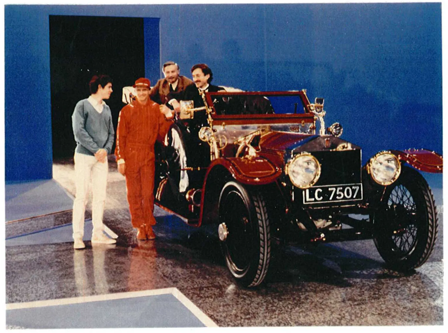 Studio recording of the DUCHESS with actors representing Charles Rolls and Henry Royce, and racing driver Niki Lauda in red, filmed for a 1986 world television special marking the automobile's 100th anniversary.